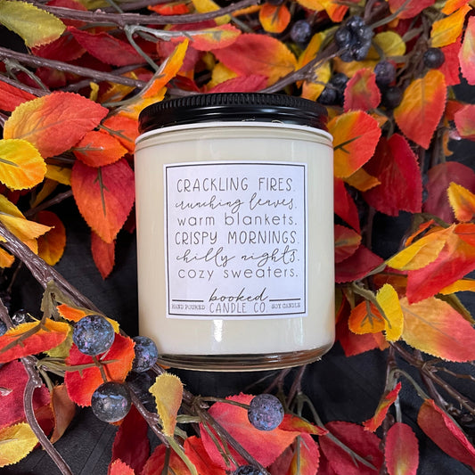Candle with a label on a decorative wreath with autumn leaves