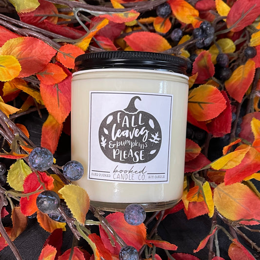 Candle with a 'Fall Leaves & Pumpkins Please' label surrounded by autumn leaves and berries