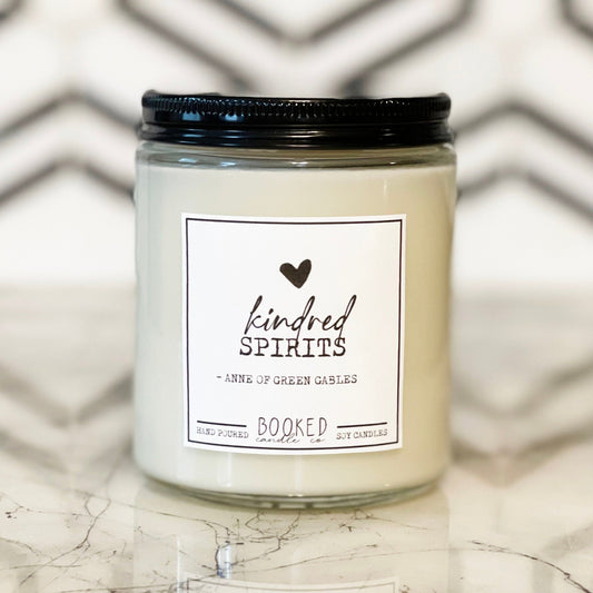 Image of a handmade candle in a glass container with a book label saying "Kindred Spirits"