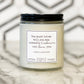 A white soy wax candle in an 8oz glass jar with a black lid, labeled 'Ardently Admire And Love - Pride & Prejudice' on a marble surface.