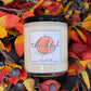 Candle with a 'thankful' label surrounded by autumn leaves and berries